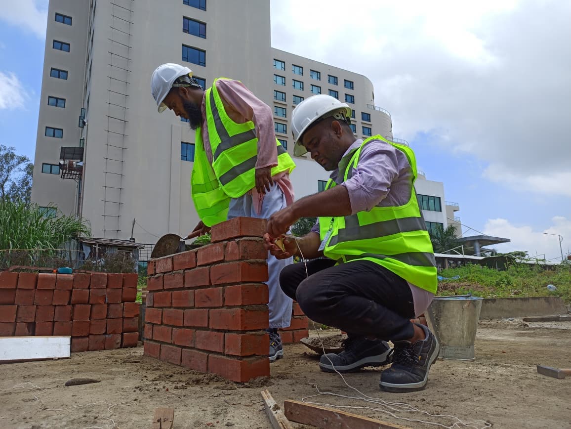 Trainees laying bricks in the Sylhet yard