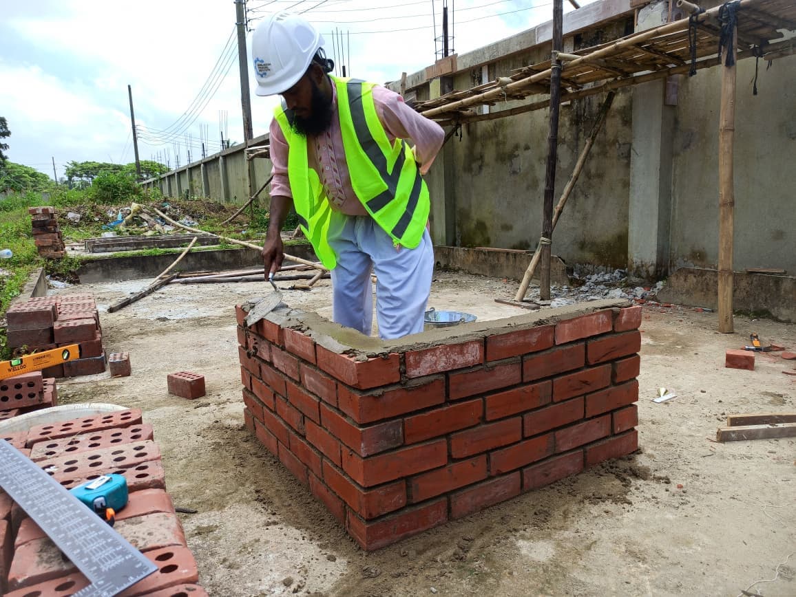 An instructor guiding a trainee on the Sylhet campus